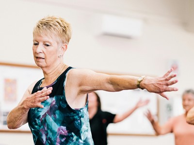 A photo of a woman over 50 in motion at a dance class