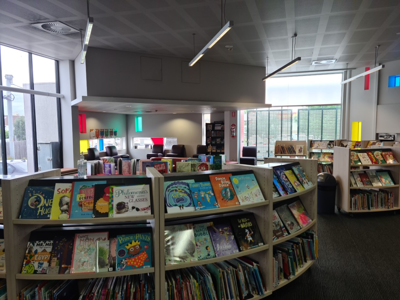 Curved bookshelves in a public library, filled with children's books