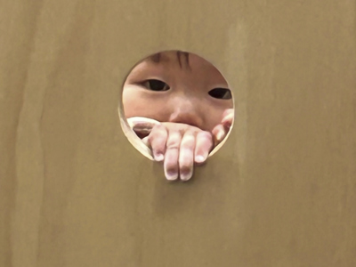 Child face seen through cut out hole