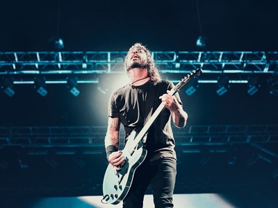 Dave Grohl playing guitar under stage light
