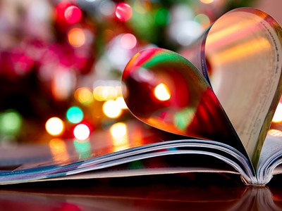A photo of a book with christmas lights in the background